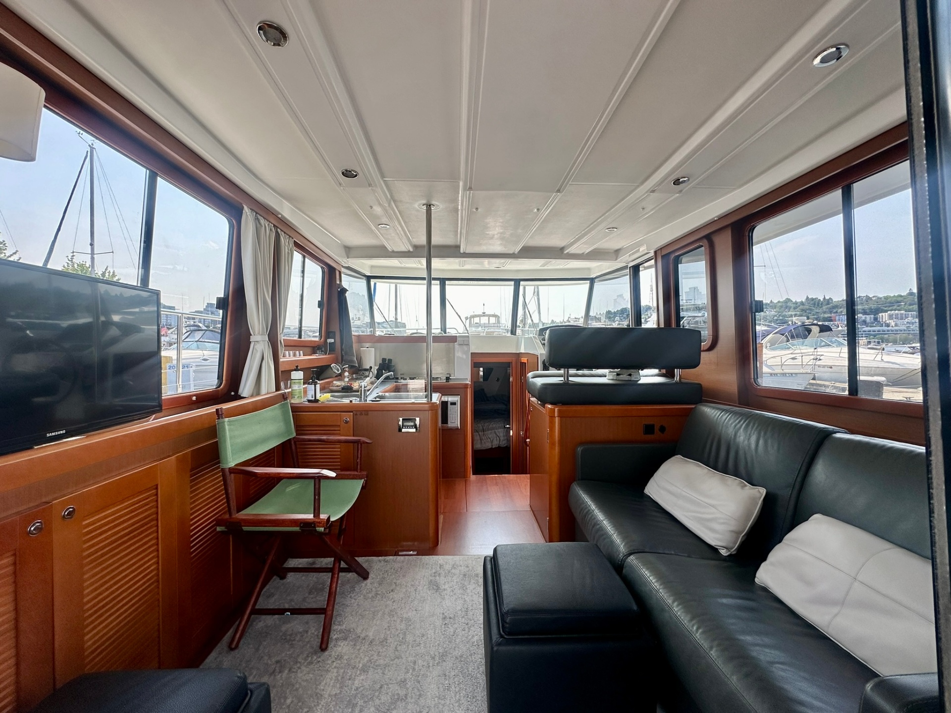 Interior salon with leather seating, galley, and marina views