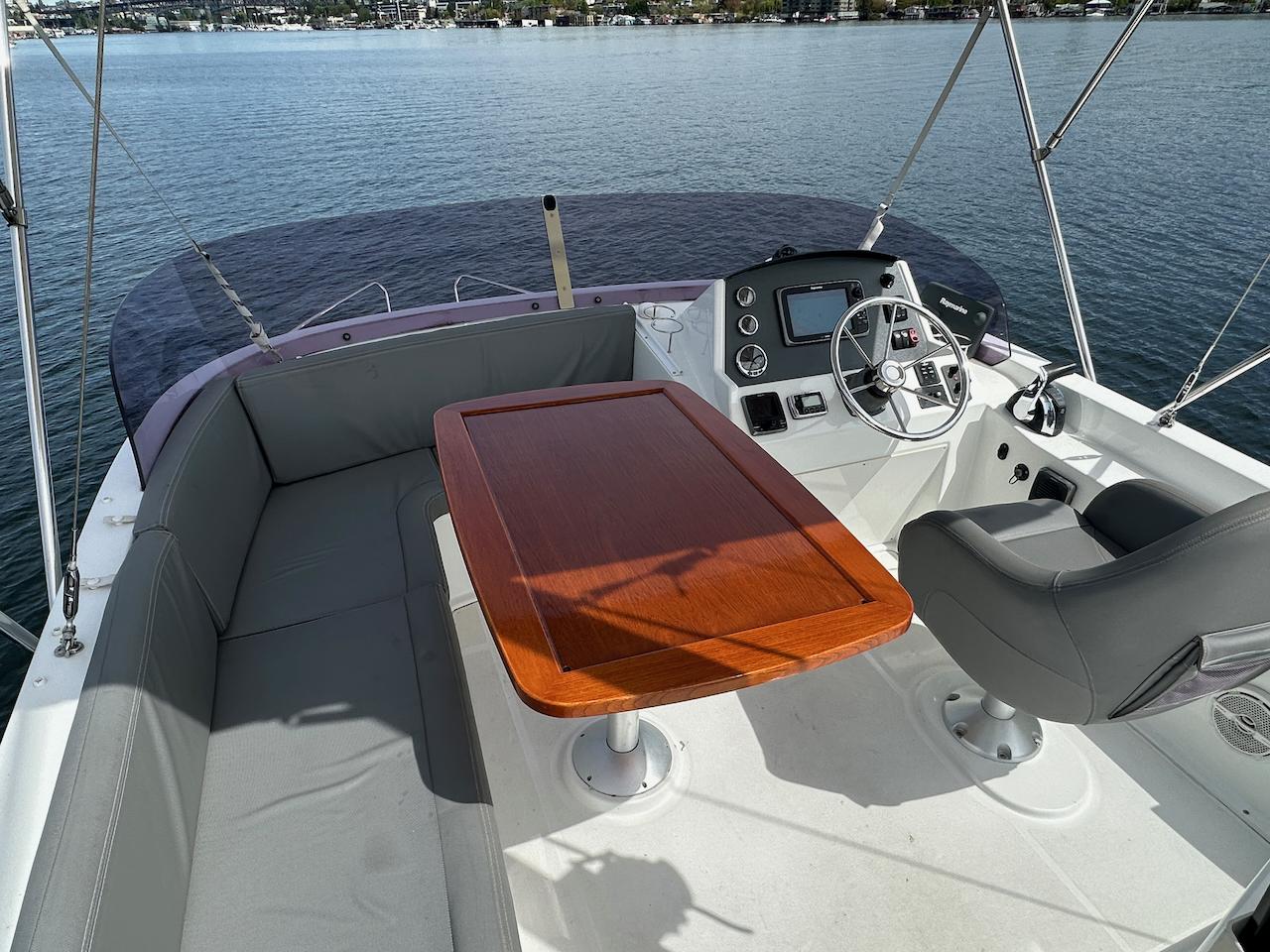 Flybridge helm with wraparound seating and a teak table on Lake Union