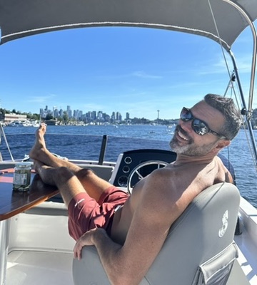 Captain Jeff relaxing on deck with the Seattle skyline